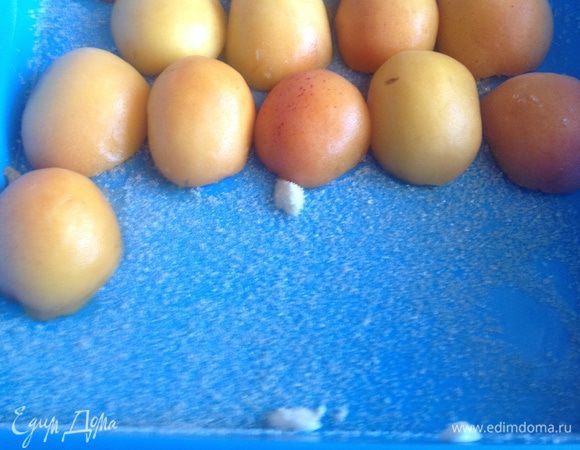 Силиконовую форму смажьте сливочным маслом, присыпьте сахаром, и выложите абрикосы, срезом вниз.