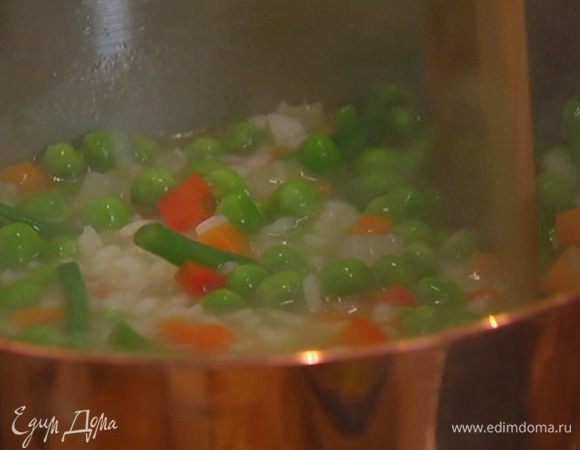 Добавить фасоль и горошек и варить еще 3–4 минуты до готовности риса и овощей, затем посолить и поперчить. Если суп получается слишком густым, влить еще немного горячей воды или бульона.