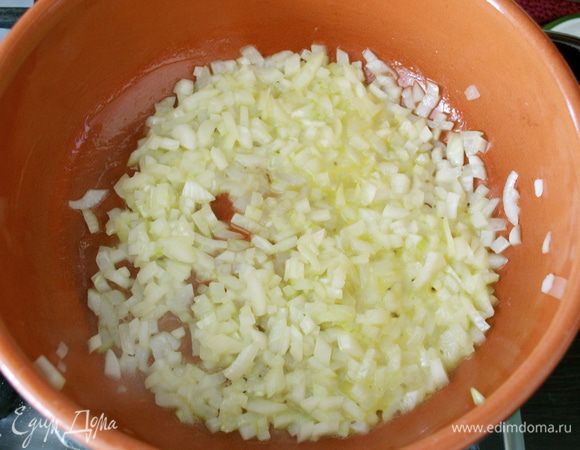Небольшую луковицу нашинковать помельче. В сковороде с тяжелым дном разогреть оливковое масло и половину сливочного (20 г). Положить в сковороду лук и обжарить на среднем огне до приобретения им прозрачности... Лук ни в коем случае не должен поджариться, а только потомиться и размягчиться. Поэтому в случае необходимости плеснуть половник бульона в сковороду к луку. (P.S. Я последнее время очень хорошо приспособила глубокую глиняную сковороду к приготовлению ризотто).     