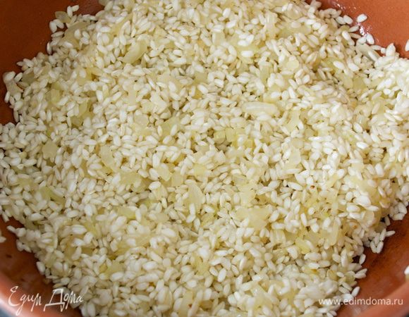 Все перемешать и позволить рису в течение одной минуты пропитаться и смешаться с луком. Через минуту увеличить огонь и влить белое сухое вино. Дать ему выпариться. 