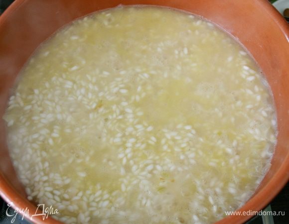 Добавить горячий (!!!) бульон... Около двух половников, так, чтобы слой жидкости покрывала рис..., как на фото. Огонь уменьшить до среднего. Продолжать готовить ризотто, подливая горячий бульон по мере того, как он будет впитываться, и время от времени помешивая. Обычно на приготовление указанного количества ризотто уходит от 16 до 18 минут максимум.  