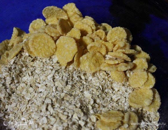 В глубокую миску высыпаем овсяные хлопья, к ним добавляем 2 ст.л. кукурузных хлопьев.