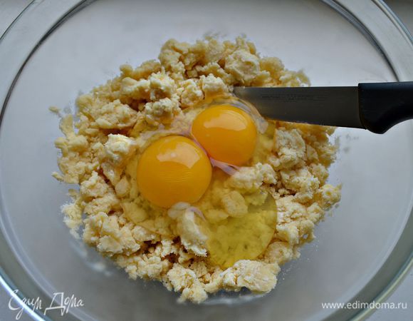 Просейте муку в охлаждённую миску. Кончиками пальцев перетрите муку и охлаждённое сливочное масло,  пока смесь не превратится в мелкие крошки.
Добавьте яйца, соль и сахар, вмешайте ножом.