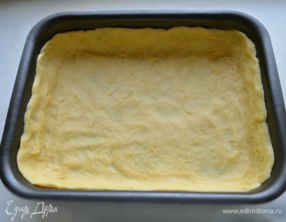БОльшую часть охлаждённого теста раскатайте и выстелите им форму, формируя бортики. Поставьте на 10 мин в морозильную камеру. 
(Я использовала прямоугольную форму 24 х 20 см, хорошо подойдёт и круглая d=26 см).
