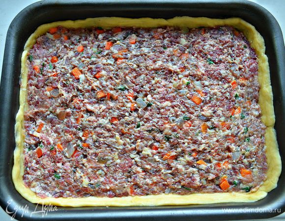 Затем нужно выложить на охлаждённое тесто начинку, аккуратно разравнивая поверхность.