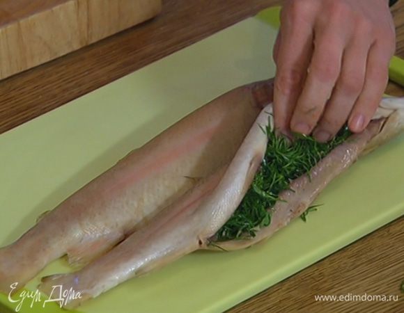 В брюшко каждой рыбы поместить измельченную зелень и несколько кружков лимона.