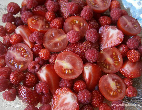 На тарелке разложить ягоды малины, земляники и нарезанные помидорки - черри и клубнику.