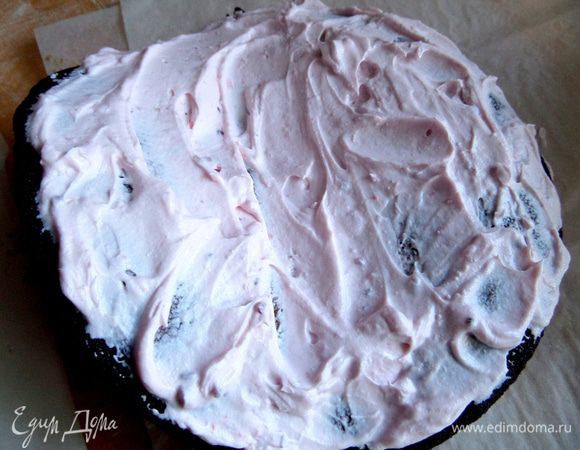 Раскрываем остывший первый корж и наносим розовый крем.