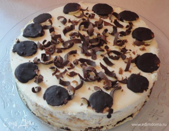 Сливки с ванильным сахаром и загустителем взбить и 1/3 крема выложить на бананы.  Накрыть вторым коржом и сверху выложить остальные сливки. Вместо указанных сливок и загустителя я использовала 40% деревенские сливки (400 г) и 200 грамм сливок 10%, в которых я замочила столовую ложку желатина, затем нагрела на водяной бане до растворения желатина. Процедила сливки, смешала с ванильным сахаром, остудила и взбила с жирными сливками. Украсить торт в рецепте предлагалось миндальными лепестками. Их у меня не оказалось и я растопила шоколад и обмакивала в нем кругленькие дольки банана, а в центр натерла шоколад.