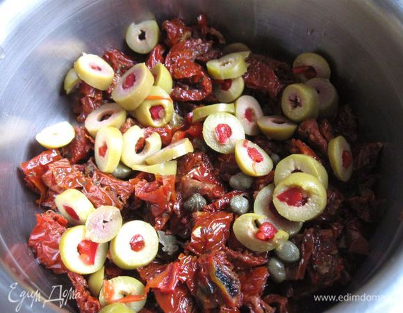 Оливки порезать колечками и добавить к помидорам и каперсам.