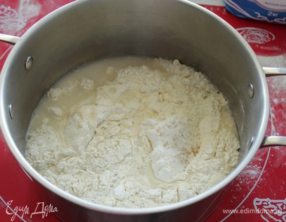 В большую емкость насыпать  муку, добавить соль и дрожжи, перемешать и влить воду.
