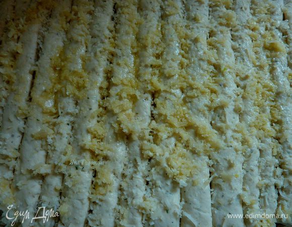 Посыпать тёртым пармезаном. 
4 зубчика чеснока выдавить через пресс и распределить ложкой на тесто, сбрызнуть оливковым маслом.
