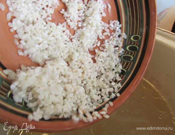 В кастрюлю налить готовый бульон. Выложить в кастрюлю картофель и рис. И варить до полуготовности.