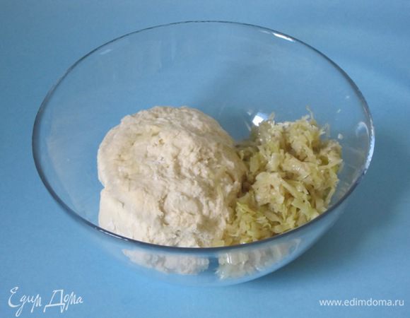 Затем добавить остывшую обжаренную капусту. Хорошо перемешать с тестом. Добавить  50 грамм муки.