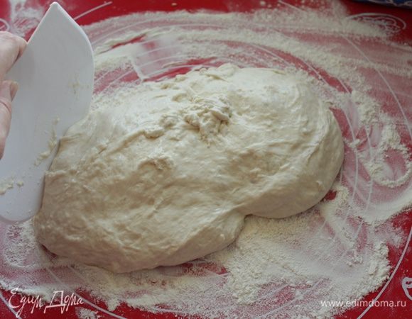 Обильно посыпать стол мукой, выложить тесто и присыпать мукой сверху так же обильно.