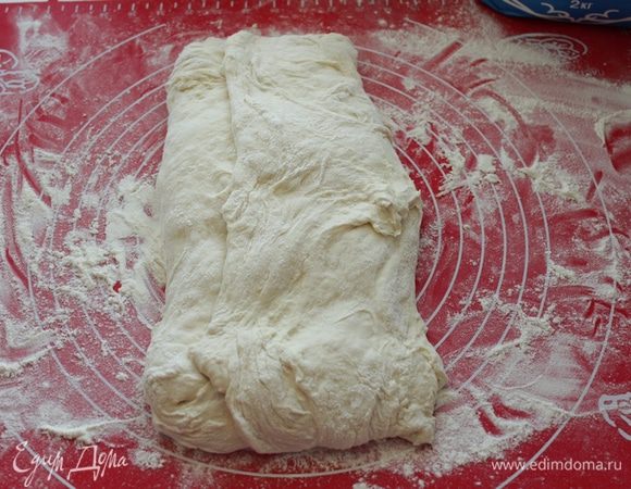 Растянуть тесто,затем сложить тесто  в конверт: сперва вдвое.