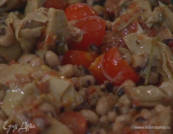 В салатницу выложить помидоры черри, артишоки, фасоль, полить все заправкой и перемешать.