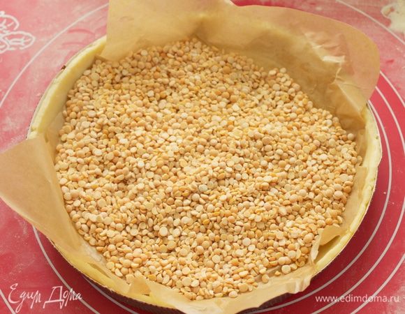 Накройте сверху пергаментной бумагой и выложите пресс .

Выпекайте тесто в заранее разогретой духовке 180 гр, 10 минут. Затем снимите бумагу с грузом и подержите еще 5 минут.