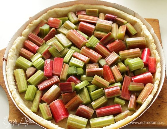 Достаньте песочную основу из духовки.
Выложите ревень.