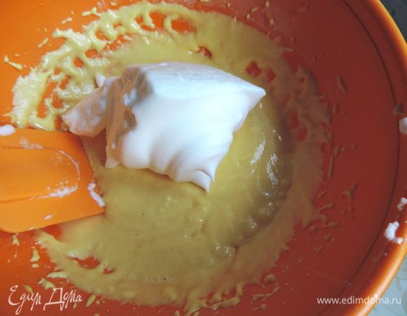 Теперь в три приема смешиваем тесто со взбитыми белками. Делаем это очень аккуратно, лопаткой, движениями снизу-вверх от краев к центру, чтоб не разрушить пузырьки воздуха. Ведь именно от них зависит воздушность бисквита, никаких других разрыхлителей в тесте нет.