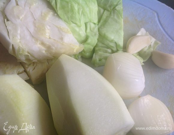 Духовку нагрейте до 200 градусов.Кабачок, лук и чеснок почистите. Капусту и кабачок нарежьте кусками.