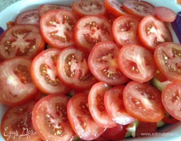 В форму мелко нарезать чеснок, все посолить, добавить вашу любимую приправу для овощей, у меня смесь трав.
Нарезать кружочками томаты, выложить сверху и еще раз посолить, посыпать молотым перцем, полить оливковым маслом.