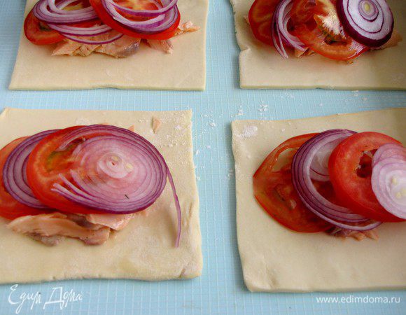 Сверху на рыбу выложить лук и помидоры.