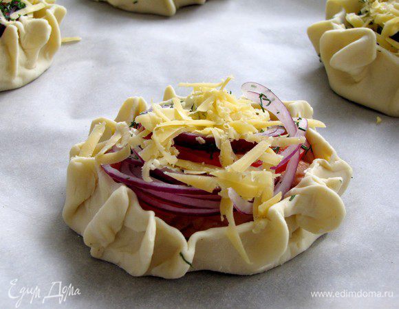 Посыпать мелкорубленым укропом и тертым сыром. Выложить на противень, застеленный пекарской бумагой и запекать в разогретой духовке (180 град) 10 минут.