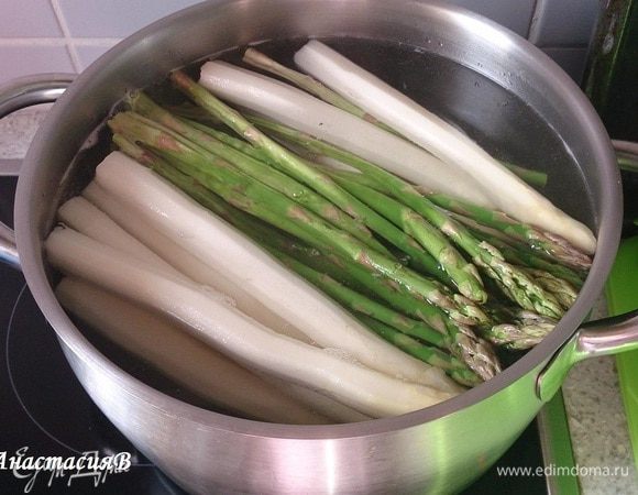Спаржу помыть. У белой спаржи почистить кожуру и отрезать 1 см от ножки, у зеленой только отрезать немного от ножки. В кипящей подсоленной воде 
в начале отварить белую спаржу 3 минуты, затем добавить зеленую спаржу и отварить еще 3 минуты. Достать из кастрюли.