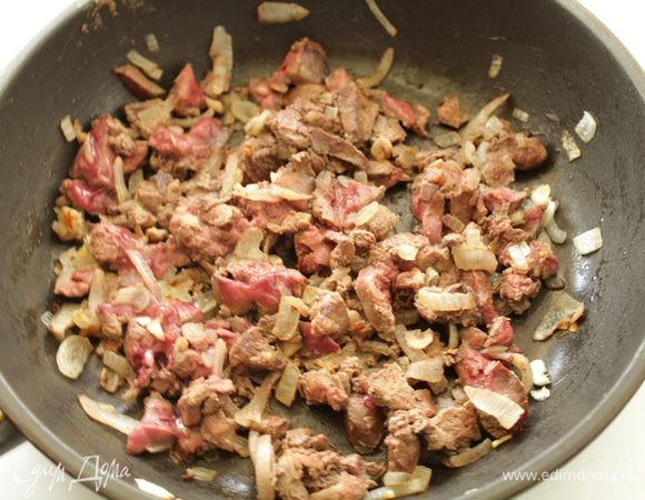 Мелко рубим лук и чеснок, затем на разогретом растительном масле обжарить, помешивая, около 2-3 минут.
Мелко нарезаем куриную печень, добавляем к луку,  жарим, помешивая, еще около 3 минут.