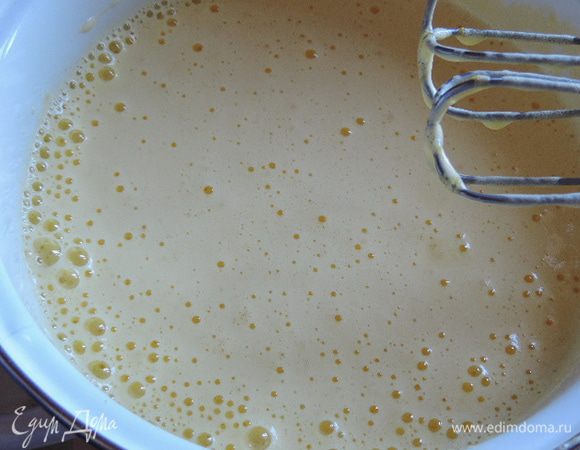 Теперь, не прекращая взбивания, сначала добавляем 2 столовые ложки кипятка, а затем тонкой струйкой вливаем масло и взбиваем до однородной пышной массы. Она станет менее густой но очень воздушной.