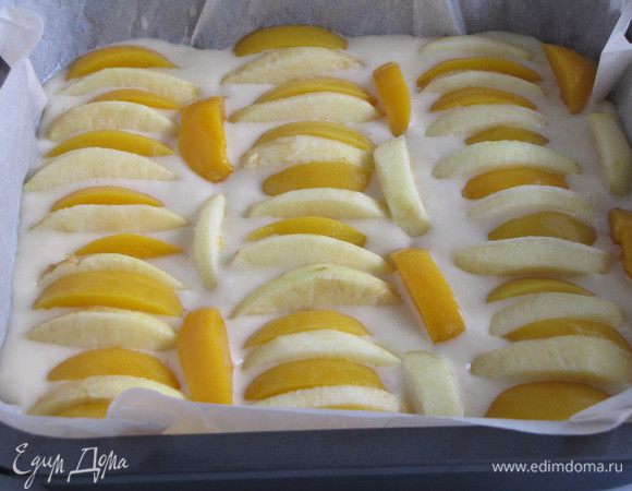 Форму для выпечки застелить пергаментом, влить тесто. У меня форма 21х21 см. Выложить на тесто рядами яблоки и персики.