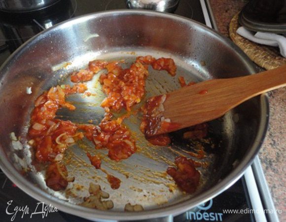 Лук почистить, мелко нарезать. В глубокой сковороде разогреть 2 ст. ложки растительного масла, обжарить на нем лук в течение 2-3 минут, добавить томатную пасту. Мне показалось скучным использовать пасту и я ее заменила острым томатным соусом. 