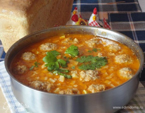 Оставшиеся ломтики батона размочить в молоке, отжать, размять и добавить в фарш. В рецепте указывается говяжий или домашний фарш, я сама приготовила свинной.  Влить в фарш яйцо, посолить, поперчить, хорошо перемешать, сформовать небольшие тефтели. Заметьте, в фарше нет привычного нам лука.
Соус довести до кипения, выложить в сковороду тефтели, закрыть крышкой и варить на среднем огне в течение 15-20 минут, затем снять с огня.
Подавать суп в глубоких мисках, посыпав зеленью. Вкусно и тоненькими тостами (если нет под рукой тортильяс).
