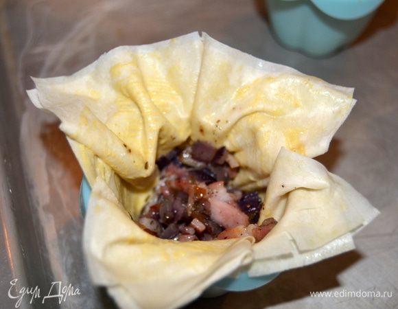 На дно выкладываем по столовой ложке начинки из бекона.