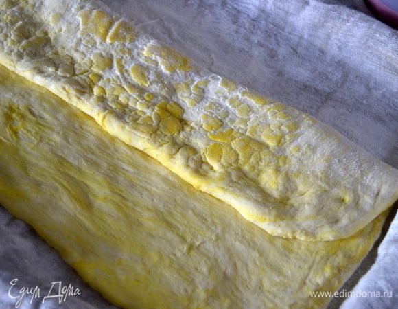 Тесто разровнять руками в прямоугольную форму.Одну треть сложить к центру прямоугольника и прижать пальцами.