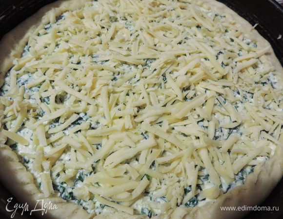 Выкладываем на тесто начинку. Лишние края бортиков загибаем на тесто. Посыпаем сверху оставшимся сыром.