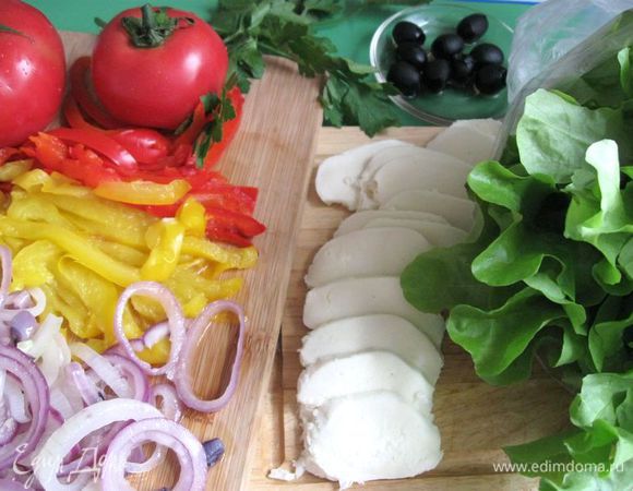 Перец болгарский помыть, разрезать на половинки, очистить от семян,  завернуть в фольгу и отправить в разогретую духовку  на 20 минут. Вынуть, развернуть,  ополоснуть холодной водой. Нарезать полосками. Моцареллу порезать. Салат помыть, откинуть на дуршлаг. Оливки порезать колечками.