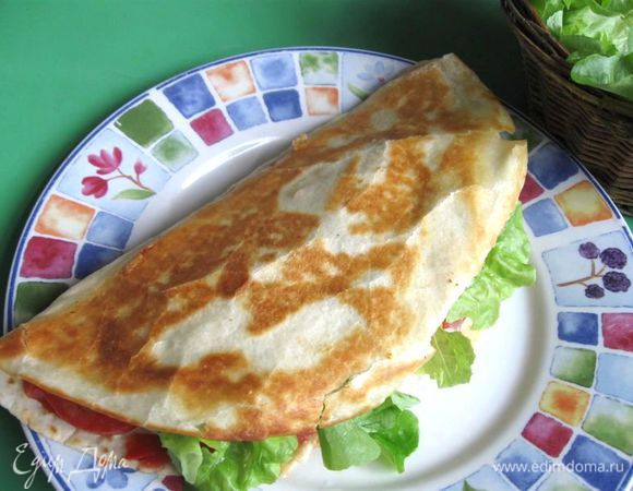 Снять со сковороды с помощью широкой лопаточки, приподнять верхнюю часть и положить листья салата внутрь лепешки.