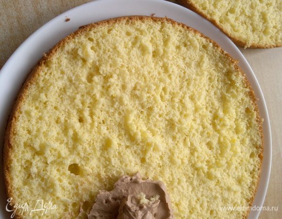 Подготовила бисквит разрезав его пополам вдоль. Крем равномерно наношу на нижний корж.