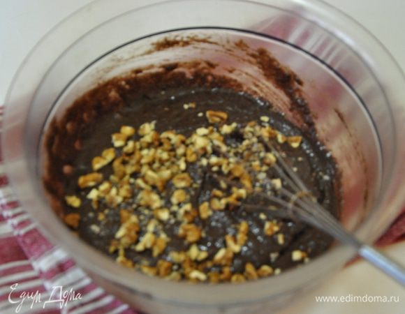 К смеси добавить рубленные не мелко грецкие орехи и снова перемешать.