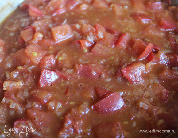 Добавить рубленные томаты, довести до кипения, через 2 минуты переложить всё в сотейник.  Туда же влить куриный бульон, заправить содержимое сотейника медом,  одной чайной ложкой рубленой кинзы, посолить, поперчить, ­довести все это до кипения, убавить огонь и томить едва булькающую гущу несколько минут, время от времени помешивая.