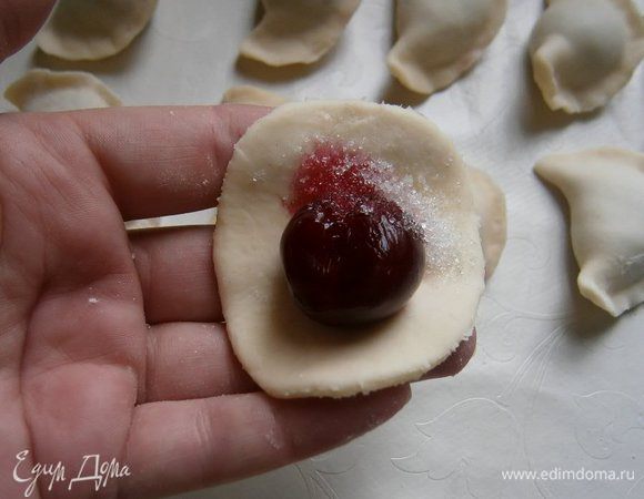 На каждый кружочек теста выложить вишню ( у меня варенички были небольшие, поэтому поместилась одна ягода)  и 1/4 ч. л. сахара, сложить пополам и хорошо скрепить края. Так приготовить 5, 10... у меня получилось 47 вареничков :))