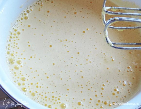 Теперь, не прекращая взбивания, сначала добавляем 2 столовые ложки кипятка, а затем тонкой струйкой вливаем масло и взбиваем до однородной пышной массы. Она станет менее густой но очень воздушной.