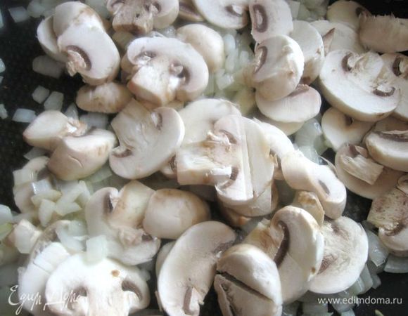 Лук порезать.  Сковороду с оливковым маслом раскалить, положить лук, начать обжаривать. Шампиньоны помыть, порезать пластинами, добавить к луку,  тушить до испарения жидкости.