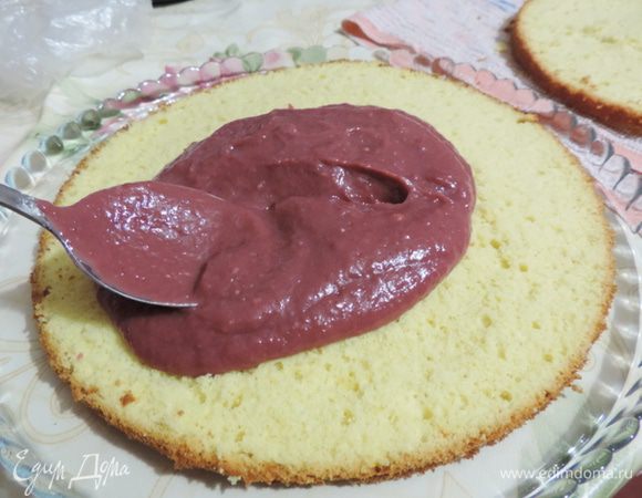 Приступаем к сборке. Выкладываем на блюдо один корж срезом верх. Равномерно распределяем по бисквиту половину курда. Он может быть еще даже теплым, так он  лучше пропитает бисквит. По второму бисквитному коржу распределяем оставшийся курд.