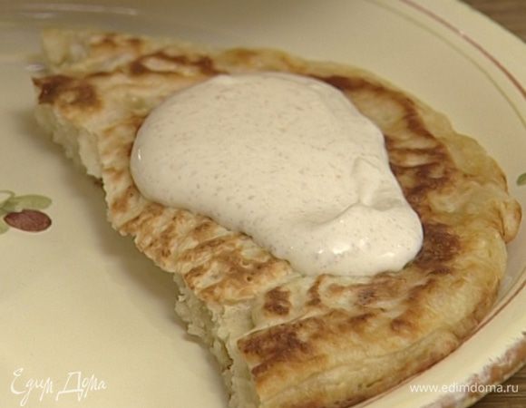 Подавать оладьи со сметанным кремом.