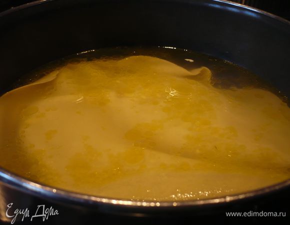 Доводим в кастрюле воду до кипения, добавляем соль, пару ложек оливкового масла. Выкладываем первый лист лазаньи. Варим его на среднем огне в течение 3 — 5 минут. Форму смазываем сливочным маслом. 