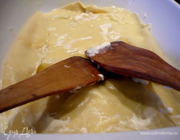 На дно выливаем немного соуса. Выкладываем первый лист лазаньи, например, при помощи двух деревянных ложек или шумовок. Расправляем лист в форме. Кладем следующий лист в кастрюлю.