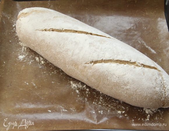 Заранее разогреть духовку до максимума вместе с противнем. На батоне сделать два диагональных надреза. 